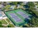 Aerial view of well-maintained community tennis courts surrounded by green space and trees at 5441 Sea Leopard St, Tavares, FL 32778