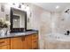 The bathroom features marble counters, a custom vanity, a soaking tub, and a tiled walk-in shower at 10417 Lake Louisa Rd, Clermont, FL 34711