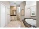A bathroom features a soaking tub with stone accents, a vanity, a glass-accented shower stall and neutral colors at 10417 Lake Louisa Rd, Clermont, FL 34711