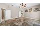 Bedroom with tile floors, open doorways, and neutral colored walls and trim at 10417 Lake Louisa Rd, Clermont, FL 34711