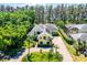 Spacious yellow home with lush landscaping, mature trees, brick driveway, and well-manicured lawn at 10417 Lake Louisa Rd, Clermont, FL 34711