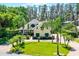 Stunning two-story home featuring a brick circular driveway, lush landscaping, and mature trees at 10417 Lake Louisa Rd, Clermont, FL 34711