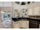 Kitchen with black granite counters, stainless dishwasher, and views to the covered patio and backyard at 10417 Lake Louisa Rd, Clermont, FL 34711
