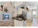 Open kitchen features a fireplace, granite counters, stainless appliances, and travertine flooring at 10417 Lake Louisa Rd, Clermont, FL 34711