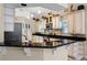 Kitchen with black granite counters, breakfast bar, stainless appliances, and white cabinetry at 10417 Lake Louisa Rd, Clermont, FL 34711