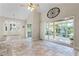 Spacious living room features a window seat, access to the screened in porch, travertine floors, and vaulted ceiling at 10417 Lake Louisa Rd, Clermont, FL 34711