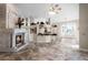 Spacious living room with stone fireplace, travertine floors, and a view into the kitchen and breakfast nook at 10417 Lake Louisa Rd, Clermont, FL 34711