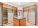 A spacious walk-in closet with custom shelving, drawers, and a central island for storage at 10417 Lake Louisa Rd, Clermont, FL 34711