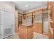 Large walk-in closet, with wooden shelving and storage units for clothing and accessories at 10417 Lake Louisa Rd, Clermont, FL 34711