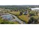 Expansive aerial view showcasing a luxurious home nestled near a serene marsh and lush greenery at 10651 Arrowtree Blvd, Clermont, FL 34715