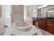 Elegant bathroom featuring a large soaking tub, separate shower, and dark wood vanity at 10651 Arrowtree Blvd, Clermont, FL 34715