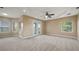 Spacious bedroom with tray ceiling, a ceiling fan, carpet floors and a private balcony at 10651 Arrowtree Blvd, Clermont, FL 34715