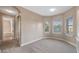 Carpeted bedroom featuring a view of the bathroom, large mirror closet, and windows for natural light at 10651 Arrowtree Blvd, Clermont, FL 34715