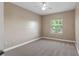 Cozy bedroom with neutral carpet, ceiling fan, and window views at 10651 Arrowtree Blvd, Clermont, FL 34715