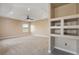 Spacious carpeted bonus room with built-in shelves, tray ceiling, recessed lights, and a ceiling fan at 10651 Arrowtree Blvd, Clermont, FL 34715
