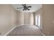 Empty bonus room featuring neutral paint, carpet and double doors to an outdoor balcony at 10651 Arrowtree Blvd, Clermont, FL 34715