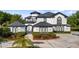 Stunning two-story home boasts a manicured lawn, beautiful landscaping, and a circular driveway at 10651 Arrowtree Blvd, Clermont, FL 34715
