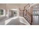 Bright living room featuring pillars, wood staircase, neutral walls, and tile flooring at 10651 Arrowtree Blvd, Clermont, FL 34715