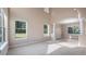 Spacious living room featuring neutral walls, tile flooring, pillars, and large windows at 10651 Arrowtree Blvd, Clermont, FL 34715
