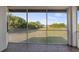 Screened-in patio overlooking lush green field and blue skies at 10651 Arrowtree Blvd, Clermont, FL 34715