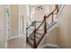 Elegant staircase with wood railing, leading to the upper level with lots of natural light at 10651 Arrowtree Blvd, Clermont, FL 34715