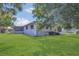 Green backyard with grass, trees, and an enclosed patio to enjoy the outdoors at 1112 Elkhart Cir, Tavares, FL 32778