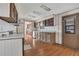 Well-lit kitchen featuring wood cabinetry, white countertops, and hardwood flooring at 1112 Elkhart Cir, Tavares, FL 32778