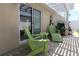 Outdoor patio with green Adirondack chairs and a pergola, perfect for enjoying sunny days at 1135 Easley Way, The Villages, FL 32162