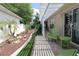Landscaped backyard featuring a patio with pergola, garden beds, and lush greenery, perfect for outdoor living at 1135 Easley Way, The Villages, FL 32162