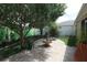 Charming backyard with stone patio, lush lawn, fountain, mature trees, and privacy fence for an inviting outdoor space at 1135 Easley Way, The Villages, FL 32162