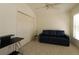 Versatile bedroom space with tile floor, large closet, and a comfortable blue sofa at 1135 Easley Way, The Villages, FL 32162