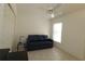 Cozy room features a blue sofa, white ceiling fan, and bright window for a welcoming space at 1135 Easley Way, The Villages, FL 32162