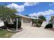 Charming home featuring a beige exterior, lush landscaping, and an attached two-car garage at 1135 Easley Way, The Villages, FL 32162