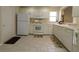 Efficient kitchen equipped with white appliances, tile flooring, and ample counter space at 1135 Easley Way, The Villages, FL 32162