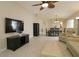 Open-concept living area with large TV, tile flooring, and neutral decor at 1135 Easley Way, The Villages, FL 32162