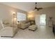 Bright living room with tiled floors, neutral walls, ceiling fan, and comfortable seating at 1135 Easley Way, The Villages, FL 32162