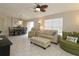 Bright living room with tiled floors, neutral walls, ceiling fan, and comfortable seating at 1135 Easley Way, The Villages, FL 32162