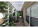 Shaded patio with white pergola, lush greenery, and brick pavers providing a serene outdoor retreat at 1135 Easley Way, The Villages, FL 32162