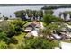Lakefront home with a solar panel system, outbuildings, mature trees, and a long driveway at 11619 Lane Park Rd, Tavares, FL 32778