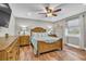 Comfortable bedroom featuring wood floors, a ceiling fan, and natural lighting at 11619 Lane Park Rd, Tavares, FL 32778