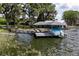 Scenic boat dock with covered boat storage and seating, set against a tranquil lake backdrop at 11619 Lane Park Rd, Tavares, FL 32778