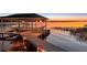 Covered boat dock featuring a boat lift and a lakeside sunset view at 11619 Lane Park Rd, Tavares, FL 32778
