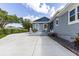 Gray house with a blue accent and white trim and a concrete driveway and steps at 11619 Lane Park Rd, Tavares, FL 32778