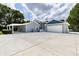 Gray exterior with white trim, a large driveway, attached garage, and covered parking at 11619 Lane Park Rd, Tavares, FL 32778