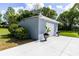 A detached, one-car garage showcases lush landscaping and a well-maintained driveway at 11619 Lane Park Rd, Tavares, FL 32778
