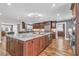 Open kitchen featuring a large island with seating, granite counters and wood floors at 11619 Lane Park Rd, Tavares, FL 32778