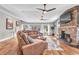 Comfortable living room with a stone fireplace, wood floors, and a view of the backyard at 11619 Lane Park Rd, Tavares, FL 32778