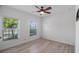 Bright bedroom featuring two windows, a ceiling fan, and light wood-look flooring at 118 Green Branch Blvd, Groveland, FL 34736