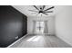 Modern bedroom features an accent wall, ceiling fan, and window offering natural light at 118 Green Branch Blvd, Groveland, FL 34736