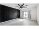 Bedroom featuring hardwood floors, a modern accent wall, ceiling fan, and natural light from the window at 118 Green Branch Blvd, Groveland, FL 34736